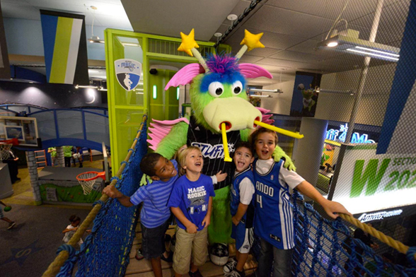 Quatro crianças estão em frente ao Stuff, o mascote do time da NBA Orlando Magic