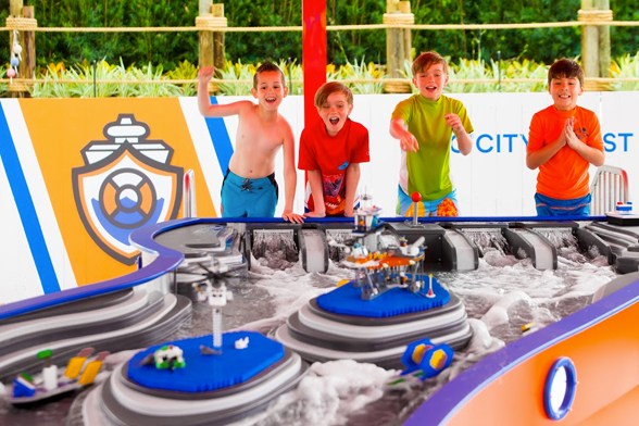 Quatro crianças sorriam e torcem na atração Build-A-Boat no LEGOLAND Water Park, perto de Orlando.