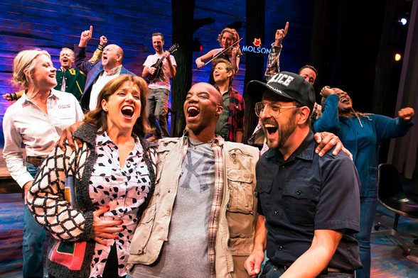 Cena do musical Come From Away, o musical da Broadway, em Nova York. Nela, atores cantam e celebram juntos.